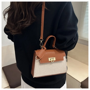 Detail of a vintage contrast flap bag with woven canvas, leather strap and gold metal buckle