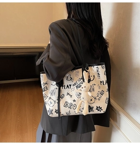Détail du sac cabas blanc avec imprimés graffiti et pendentif lapin en peluche