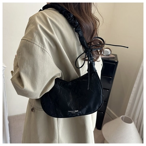 Minimalist black drawstring nylon cloud bag with ruched handle and bow detailing