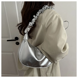 Détail du sac hobo argenté avec texture métallique et bandoulière plissée tendance