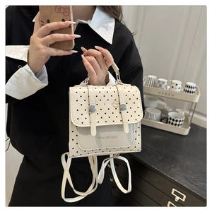 Detail of white polka dot mini backpack with adjustable straps and tidal print