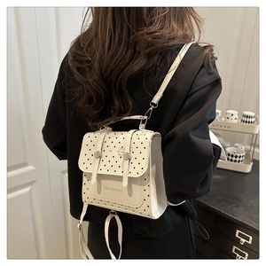 Polka dot backpack detail showing stylish white faux leather texture and buckled straps