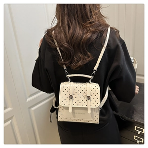 Rear view of model wearing a stylish white polka dot mini backpack with Tidal Dryness text