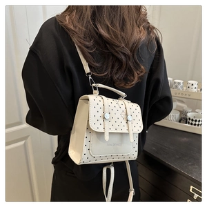 Kleiner cremefarbener Polka-Dot-Rucksack am Model zur Darstellung von Größe und Stil