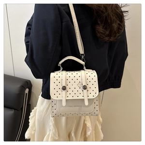 Detail of white polka dot crossbody bag featuring a metal buckle and tidal dryness print