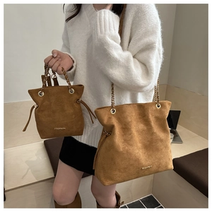 Detailed comparison of large and small brown suede bucket bags with chain straps