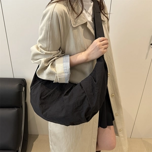 Minimalist black crescent crossbody bag with textured fabric for women in casual daily style