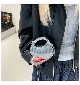 Pochette chic en acrylique argenté avec texture plissée et poignée ronde sur un modèle