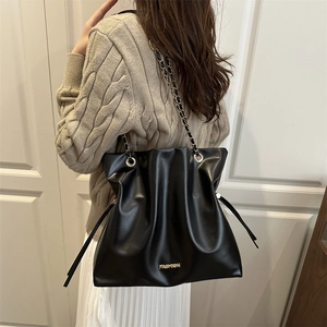 Bolso bombonera minimalista de cuero negro con cadena dorada y logotipo de moda