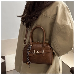 Brown faux leather crossbody shell bag with gold hardware and woven rope charm detail