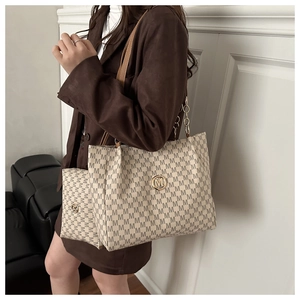 Vue détaillée du sac cabas beige avec imprimé lettres M et bandoulière chaîne en cuir