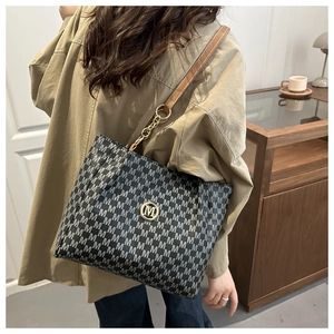 Détail du sac cabas gris jacquard avec motifs M et bandoulière en cuir brun dorée