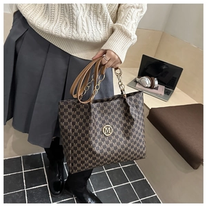 Détail du sac cabas avec logo M, bandoulière chaîne et tenue chic pour le travail
