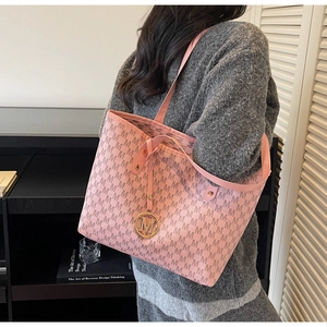 Détail du sac cabas rose à monogramme avec bandoulière et pendentif logo doré