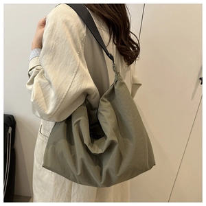 Detail of olive green pleated messenger bag with adjustable wide shoulder strap for women
