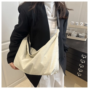 Vue détaillée du grand sac bandoulière blanc cassé avec tissu texturé et sangle noire