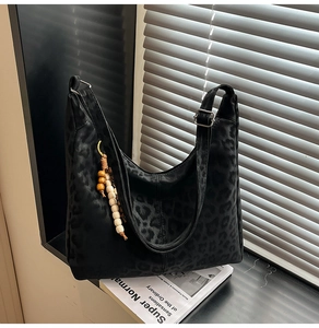Detail of black leopard print hobo bag with vintage wooden beads and wide strap