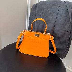 Bolso de mano naranja brillante con patrón de cocodrilo y detalles en metal dorado