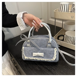 Vue détaillée du mini sac en denim bleu avec poche en dentelle et détails de nœud argenté