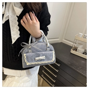 Detail of light blue bow handbag with lace trim and black and white checkered ribbon