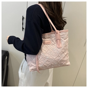 Dettaglio della borsa tote rosa chiaro con ricamo floreale ed etichetta Tidal Dryness