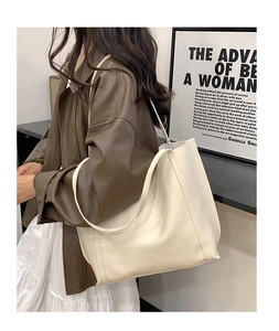 Minimalist creamy white large tote bag styled with a leather coat for office commute