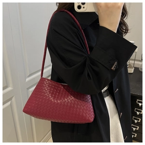 Vista dettagliata della trama intrecciata in pelle bordeaux di una borsa artigianale