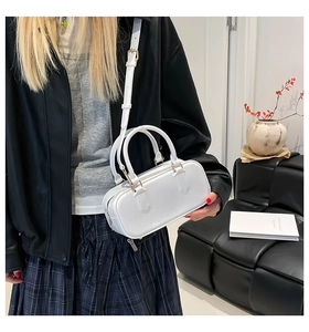 Chic white minimalist underarm bag shown as part of a modern fashion outfit