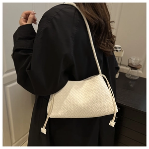 Dettaglio borsa sottobraccio in pelle intrecciata crema con coulisse e tracolla sottile