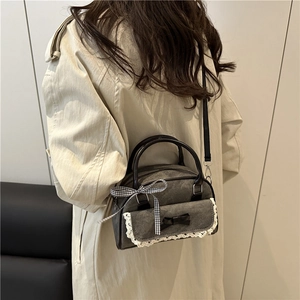 Grey denim pillow bag with lace and bow detailing shown on model shoulder