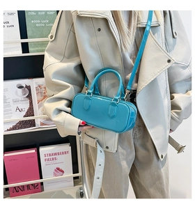 Model wearing a bright blue jelly pillow bag with glossy finish and detachable shoulder strap