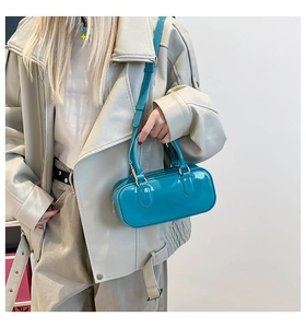 Detailed view of glossy lake blue Boston bag with twin handles and adjustable shoulder strap