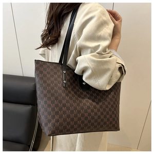Close-up of the vintage brown tote bag with M-letter pattern and leather strap