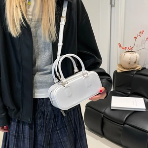 White minimalist jelly pillow bag with adjustable strap worn by model in a chic studio