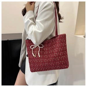 Detail der roten Tweed-Stofftasche mit Perlen-Schleife und goldener Kette