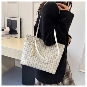 Detail der Tweed-Schultertasche mit elegantem Band, Perlenanhängern und Lederriemen