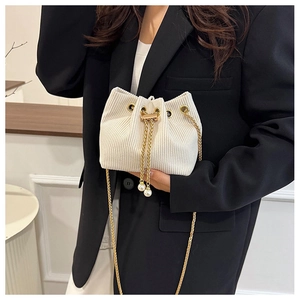 Dettaglio della mini borsa a secchiello in velluto beige con catena e perle