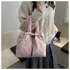 Gros plan du motif de cœur matelassé sur le sac à main rose léger pour femmes