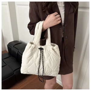 Détail du sac cabas matelassé crème avec motifs de cœurs et fermeture à cordon réglable