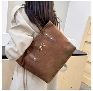 Vue détaillée du sac cabas patchwork marron avec noeud en métal et bordure en cuir