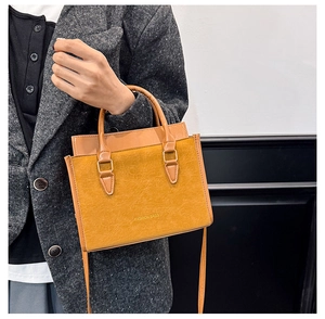 Détail de la texture d'un sac à main jaune avec l'inscription dorée FASHION BAGS
