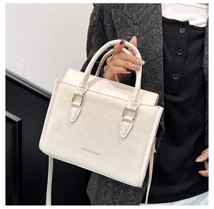 Détail du sac bandoulière rectangulaire blanc crème avec poignées et texte mode