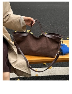Detailed view of deep brown matte tote bag with shoulder strap on a wooden park bench