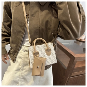 Detail of woven texture small square bag with detachable purse and brown strap
