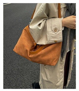 Chic tan faux suede hobo tote bag shown worn with a stylish autumn trench coat