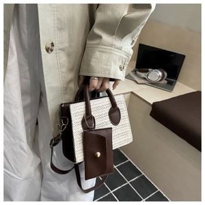 Détail du sac rétro en paille tressée et cuir marron avec mini breloque et boucle dorée