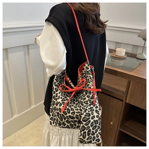 Detailed shot of leopard print tote bag with red ribbon strap and matching coin purse