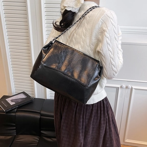 Chic black pleated leather shoulder bag with silver chain strap in a retro style