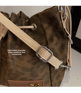 Detail of adjustable beige leather shoulder strap with silver buckle on leopard print bag