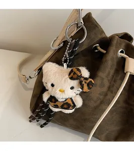 Detail of plush Hello Kitty charm with leopard print bow on a corduroy handbag